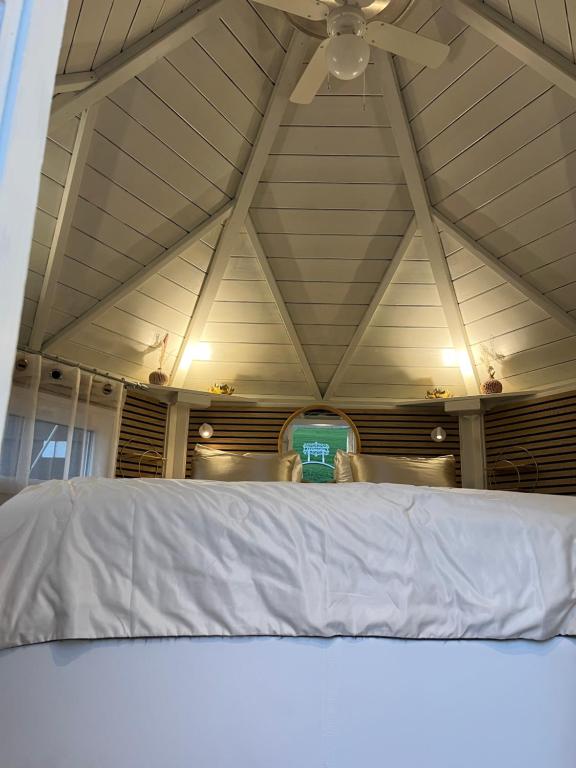 a white bed in a room with a ceiling at B&B Chalet Grillkota in Trasadingen
