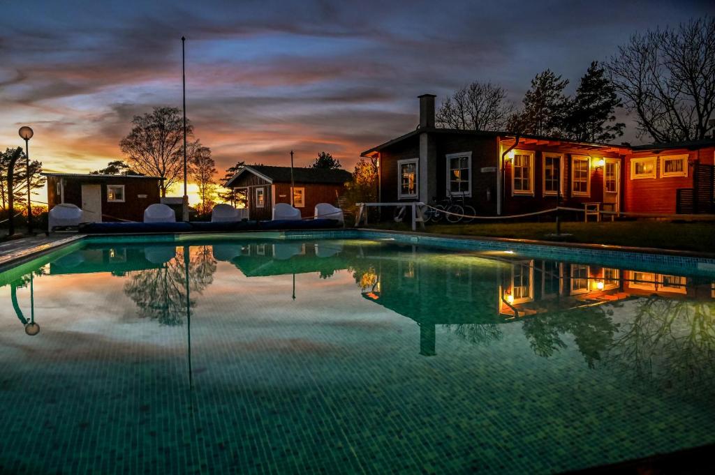 a swimming pool in front of a house at night at Strandbacka Stugor in Gnisvärd