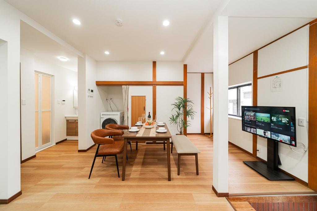 a dining room with a table and chairs and a television at NISHIKI Ryokan錦旅館 in Tokyo
