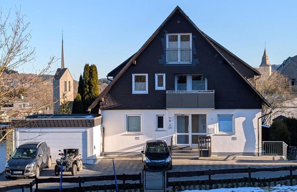 a house with two cars parked in front of it at Ferienwohnungen Citylight Winterberg in Winterberg