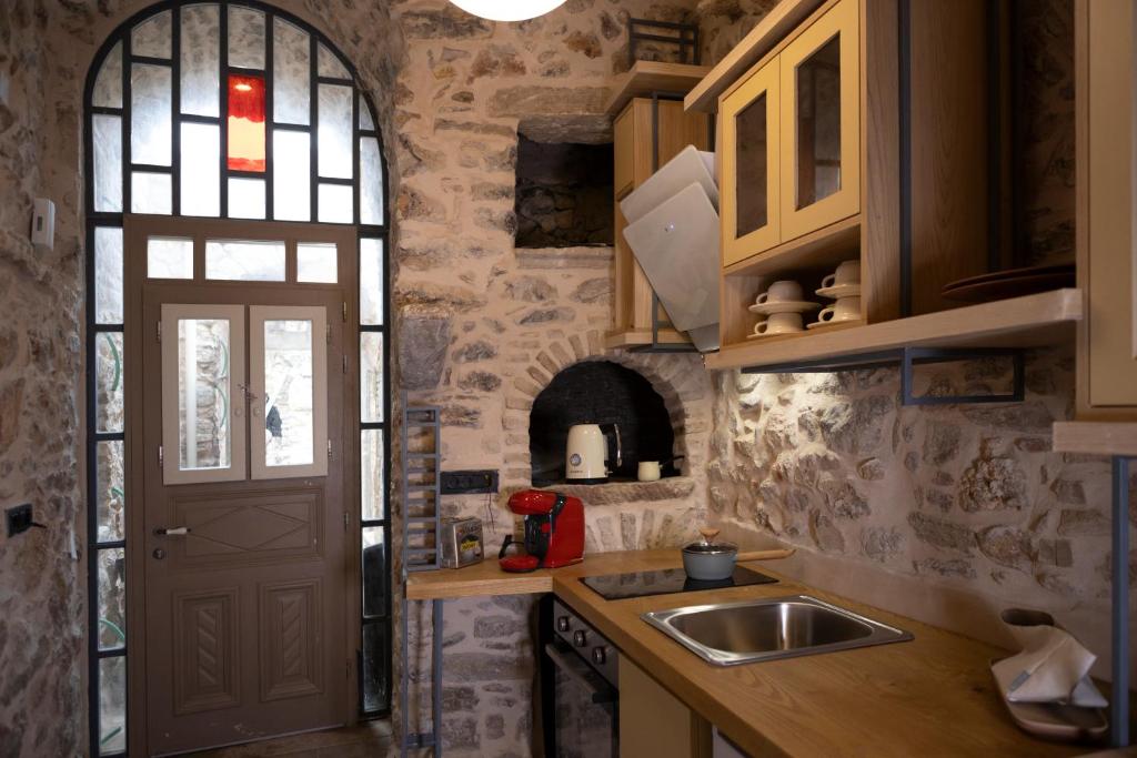 a kitchen with a sink and a window and a door at Yermata Kalamoti in Kalamoti