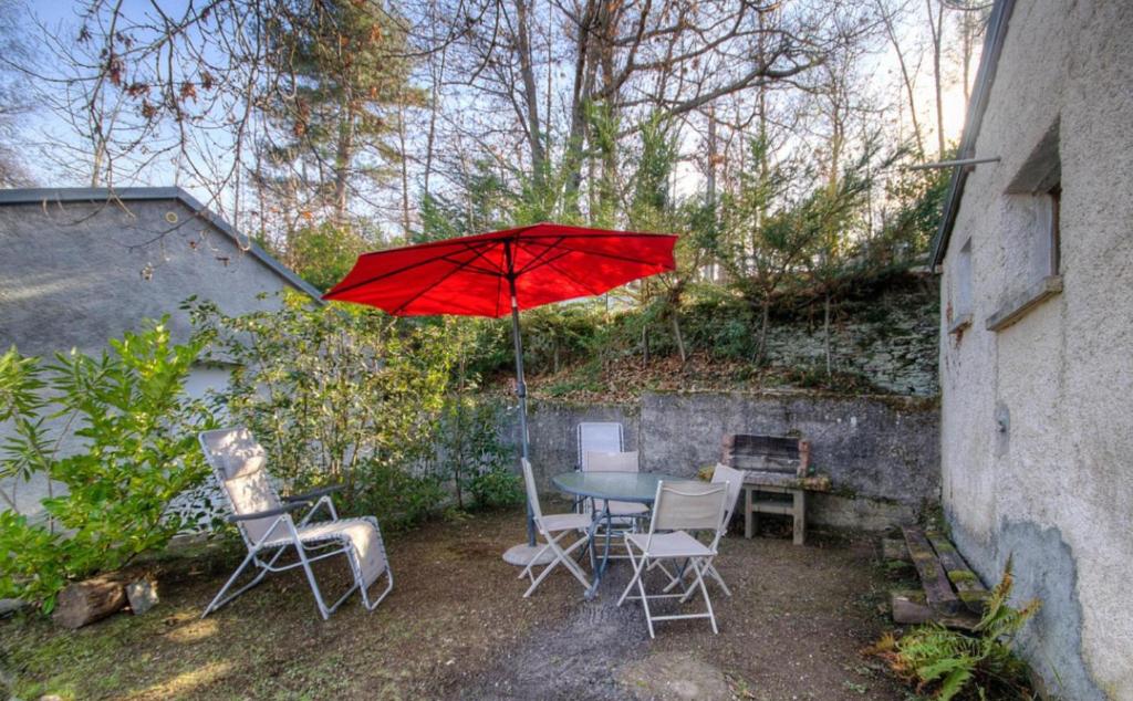 a table and chairs with a red umbrella at Casa Lisandru in Croce