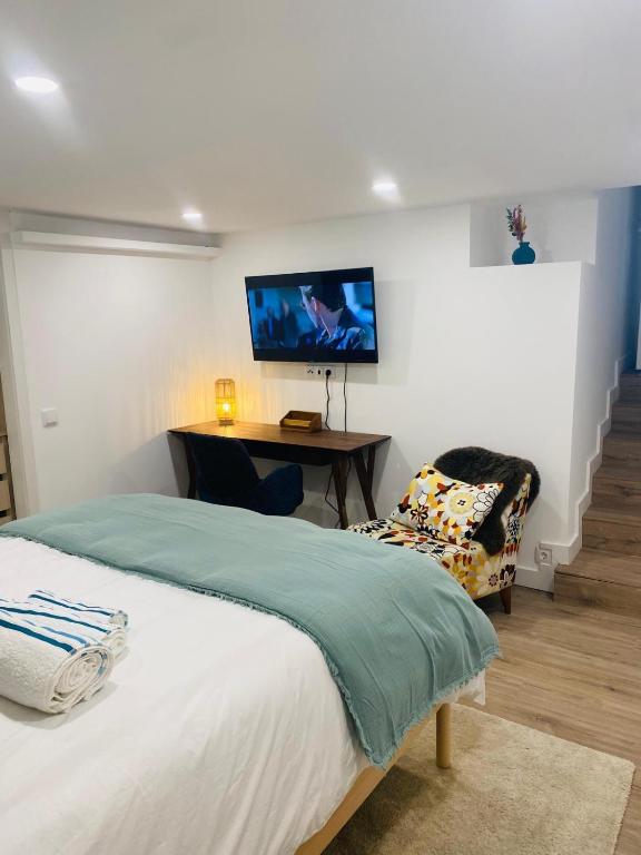 a bedroom with a bed and a tv on the wall at Confort à Loulé in Loulé