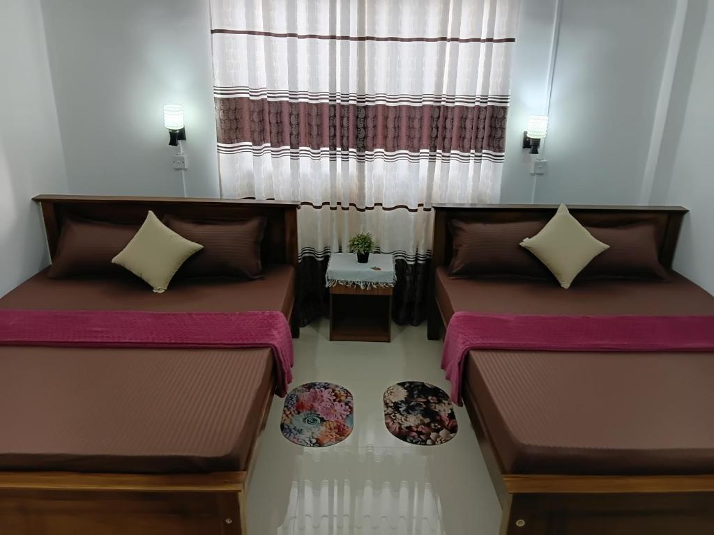 two beds in a room with a window at katunayake city apartment in Katunayaka