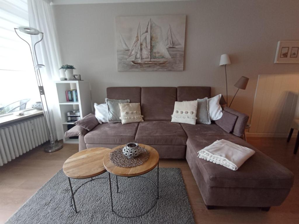 a living room with a brown couch and a table at Strandhotel - 37 in Dahme