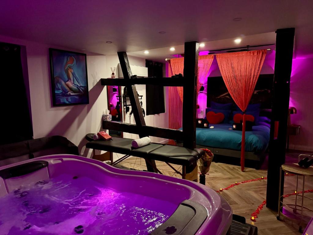 a purple room with a tub and a bed at Le fruit défendu 67 in Brumath