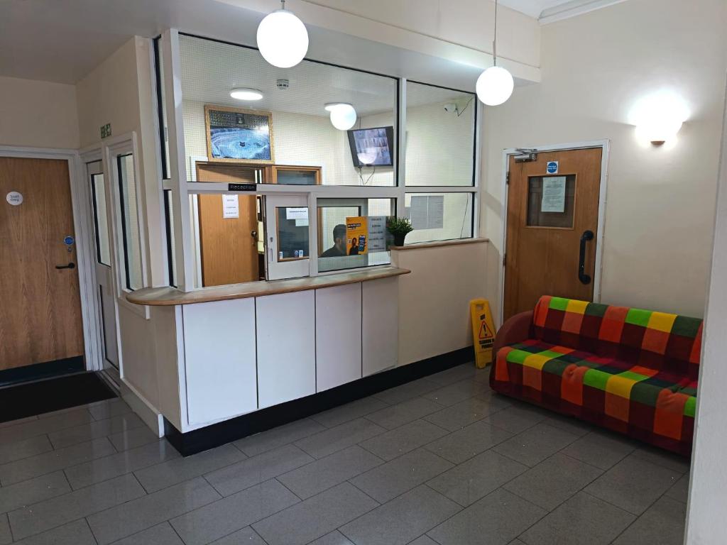 a waiting room with a couch and a window at Ilford York Hotel in Ilford