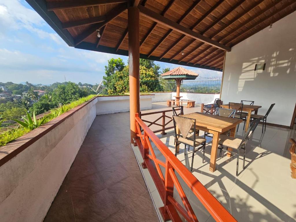 a patio with tables and chairs on a roof at Queens Residence Homestay in Kandy