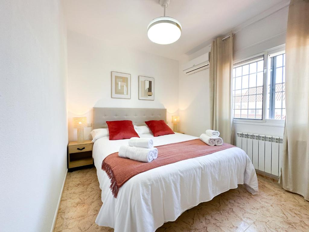 a bedroom with a large white bed with red pillows at El Retiro de Albarreal - Chalet 3 hab, Aire Acondicionado y Entrada Piscina Gratuita in Albarreal de Tajo