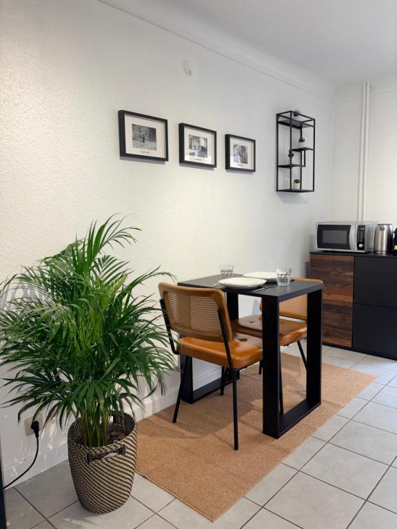 a dining room with a table and a plant at Apartment Café Ettelbrück in Ettelbruck