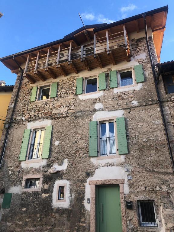 an old building with green doors and windows at Dimora Concordia in Calavino