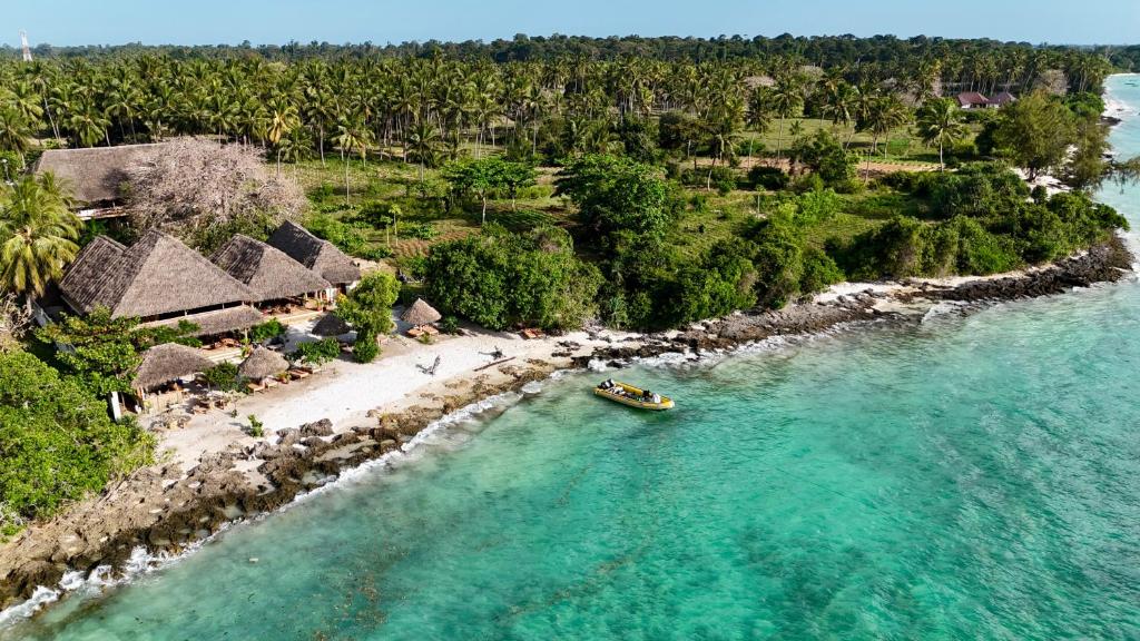 a boat in the water next to a beach at Afro Divers Lodge in Miperani