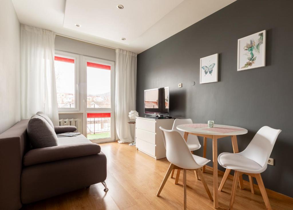 a living room with a couch and a table and chairs at Reda Cozy Nest Apartment by BookingHost in Reda