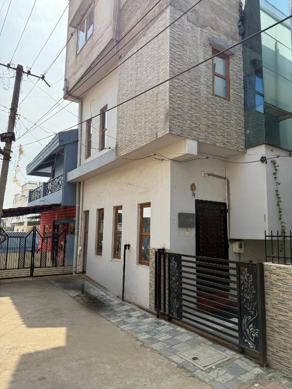 a white building with a black gate on a street at Vadodara Homestay in Vadodara