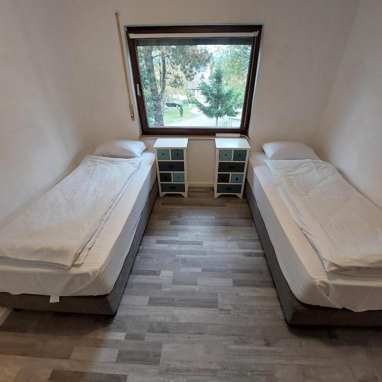 two beds in a small room with a window at Ruheoase im Südschwarzwald in Albbruck
