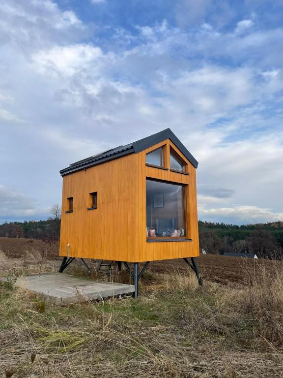a tiny house sitting on top of a field at Glampeak Adamov in Adamov