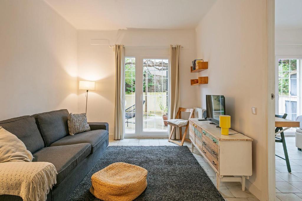 a living room with a couch and a tv at Winahost Apartament Cirerer in Valldoreix