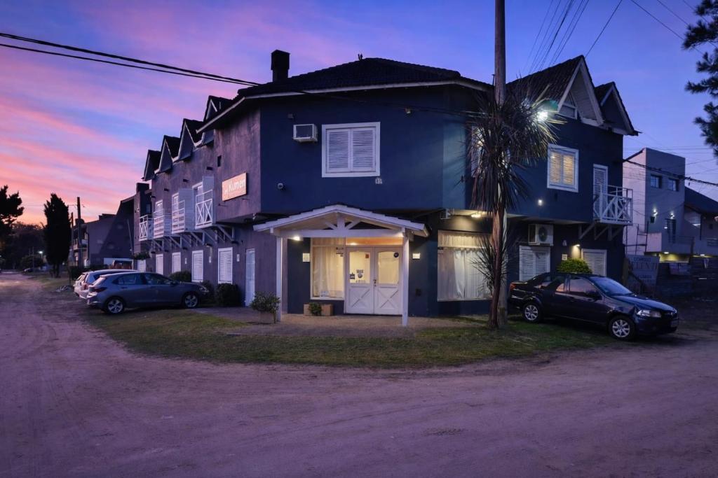 a blue house with two cars parked in front of it at Kumen Apart de Playa in San Bernardo