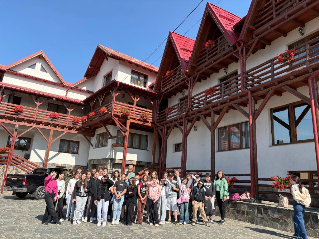 a group of people standing in front of a building at Pensiunea Valcinet in Borşa