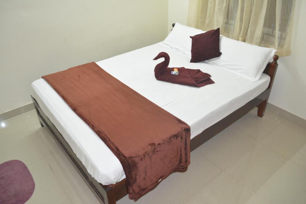 Un dormitorio con una cama con un cisne. en JP Nivaas Guest House en Mayiladuthurai