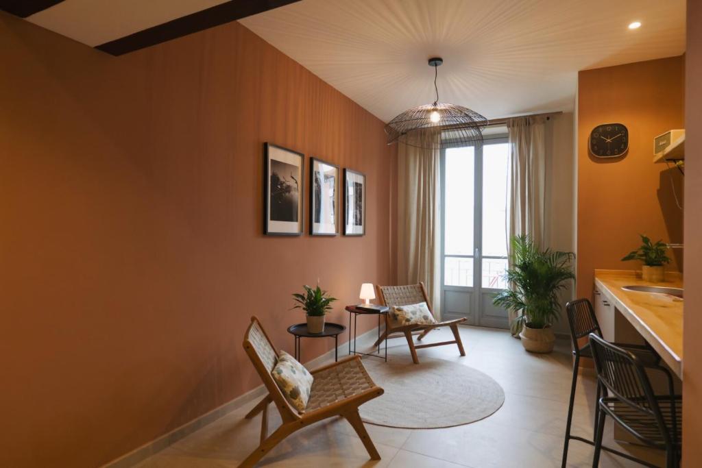 a living room with orange walls and chairs at Camillò Guest House in Ivrea