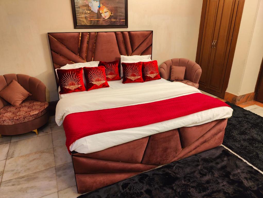a large bed with red pillows in a bedroom at Shri Rang Ji Palace in Vrindāvan