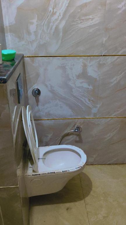 a toilet with the seat up in a bathroom at Sahib ka Ghar in Kharar