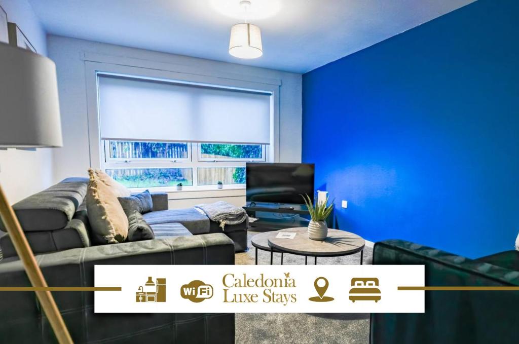 a blue living room with a couch and a window at Sedgebank House in Livingston