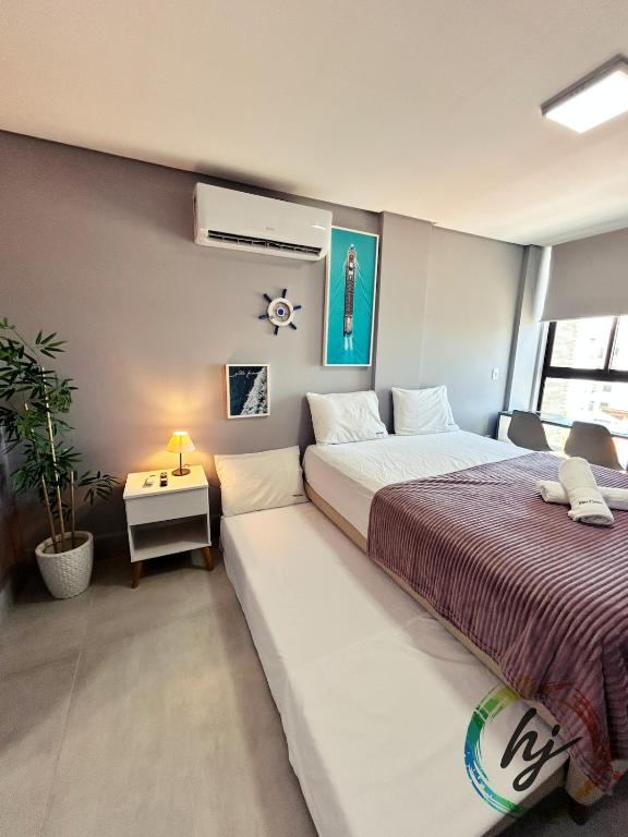 a bedroom with two beds and a plant in it at Vista Mare 402 in Ilha da Restinga