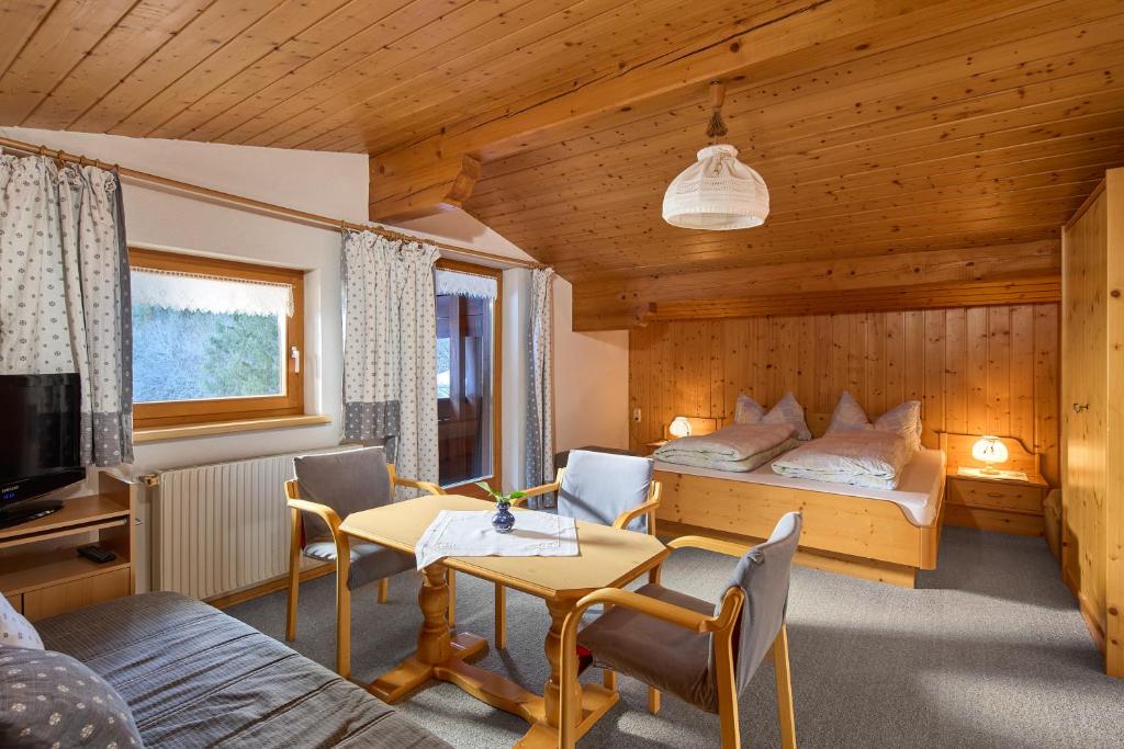 a bedroom with a bed and a table and chairs at Haus Muster - Hochmontafon in Partenen