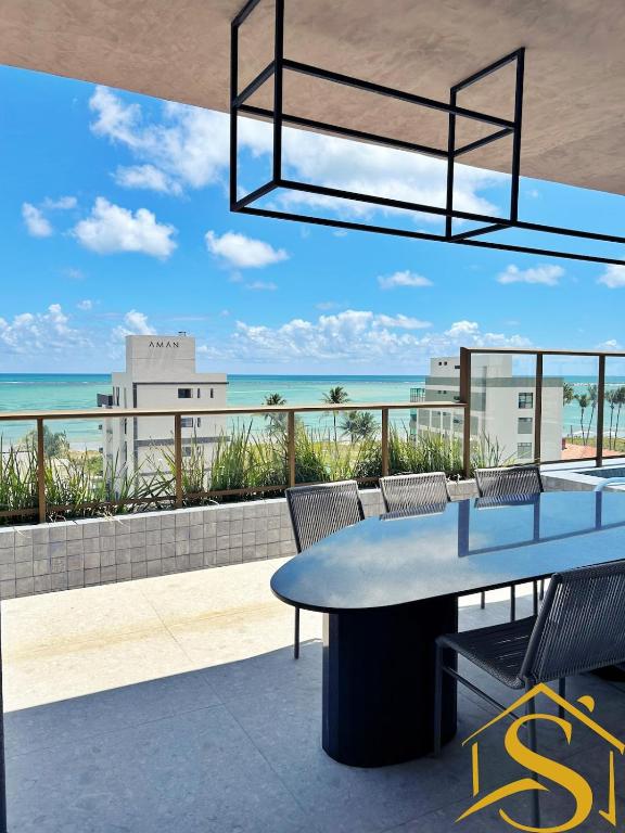 a patio with a table and chairs and the ocean at Ble Camboinha 101 in Camalaú
