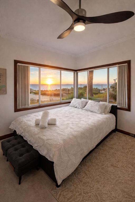 a bedroom with a large bed with a ceiling fan at Upper Esplanade Oceanview Escape in Bunbury