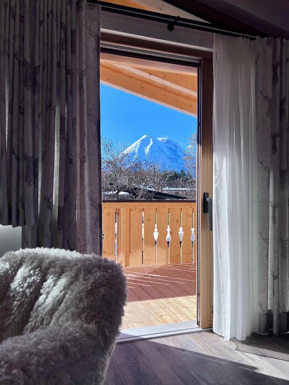 a sliding glass door with a view of a mountain at Chalet Hirschegg - modernes Dorfchalet mit Panorama in Leutasch