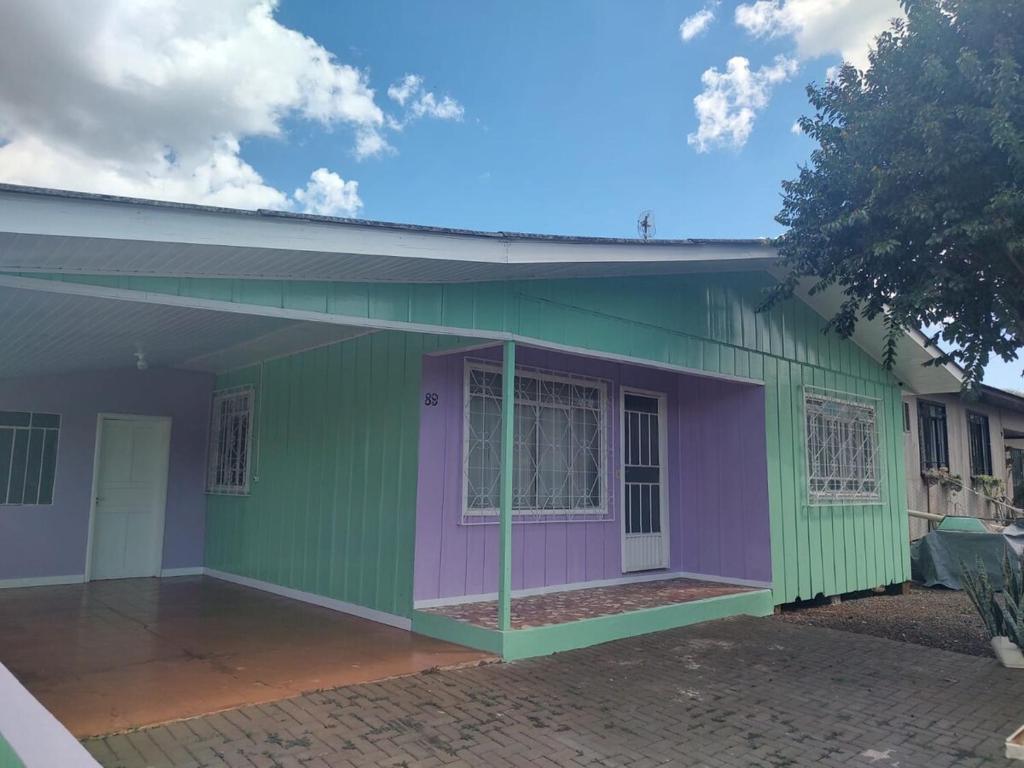 a house with a green and purple at Um lar acolhedor in Pato Branco