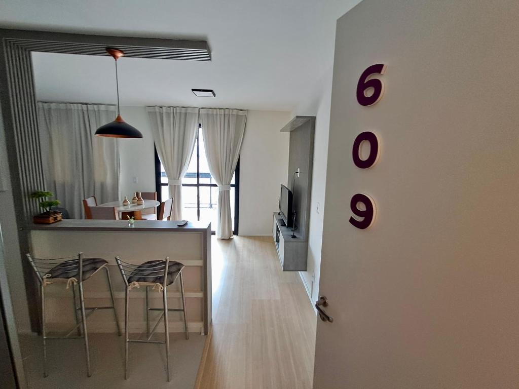 a room with a kitchen and a bar with stools at Loft Próximo à Praia de Icaraí in Niterói