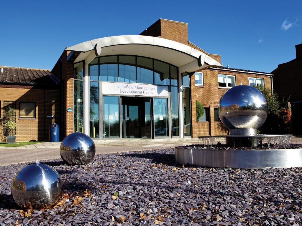 een gebouw met twee grote metalen ballen ervoor bij Cranfield Management Development Centre in Cranfield