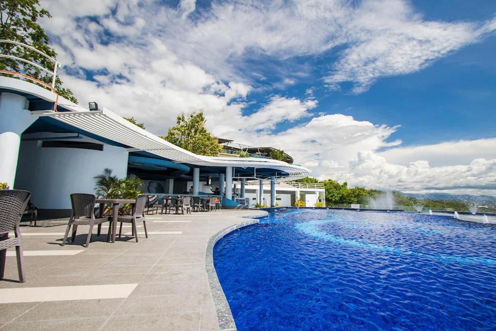 a resort swimming pool with chairs and a building at Amaya View in Balulang