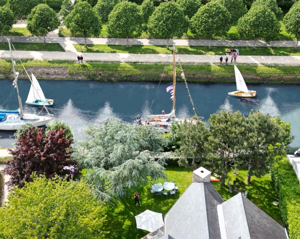 an aerial view of boats in a river with trees at La villa M Vannes, villa les pieds dans l'eau sur le port, avec grand jacuzzi in Vannes