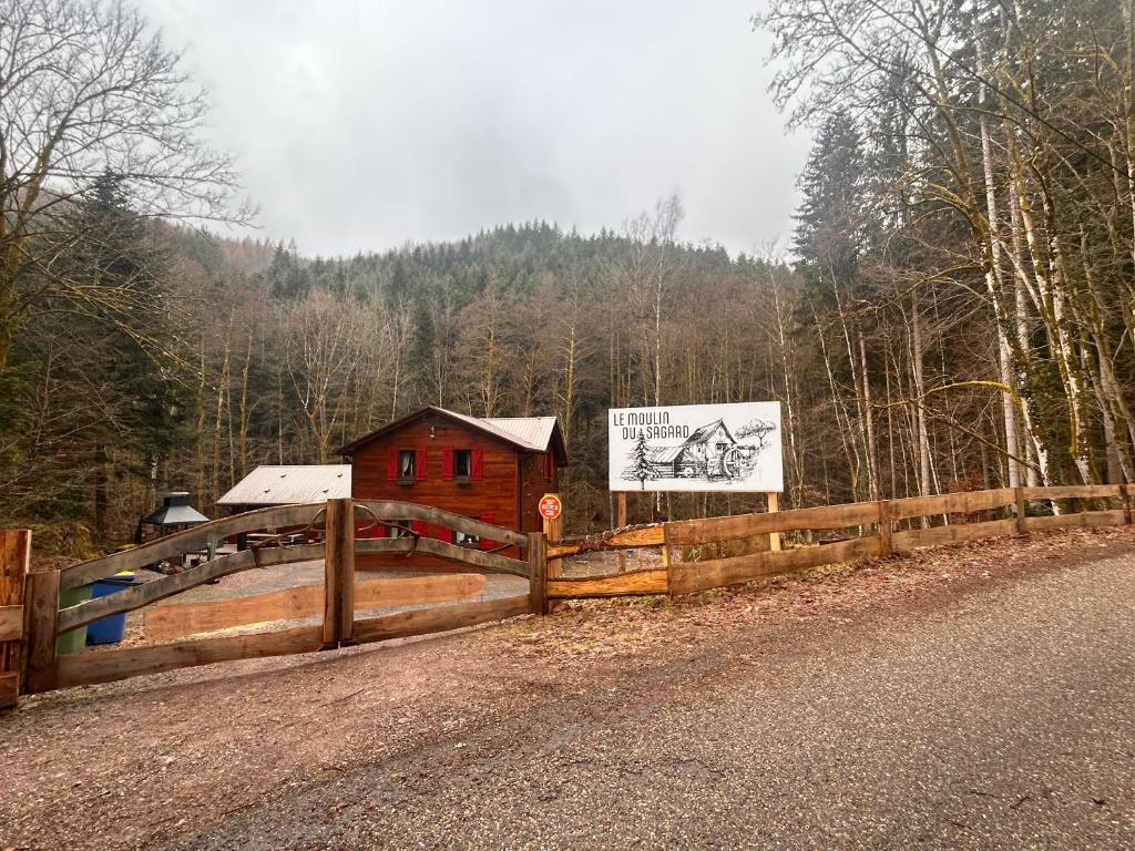 a wooden fence next to a building on the side of a road at Chalet : le moulin du sagard in Wisches