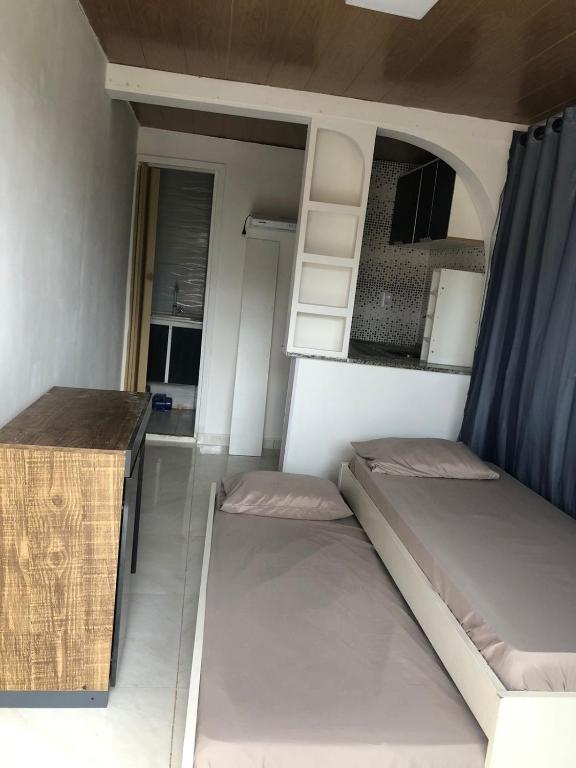 a small room with two beds and a table at Container Black in Pedra de Guaratiba