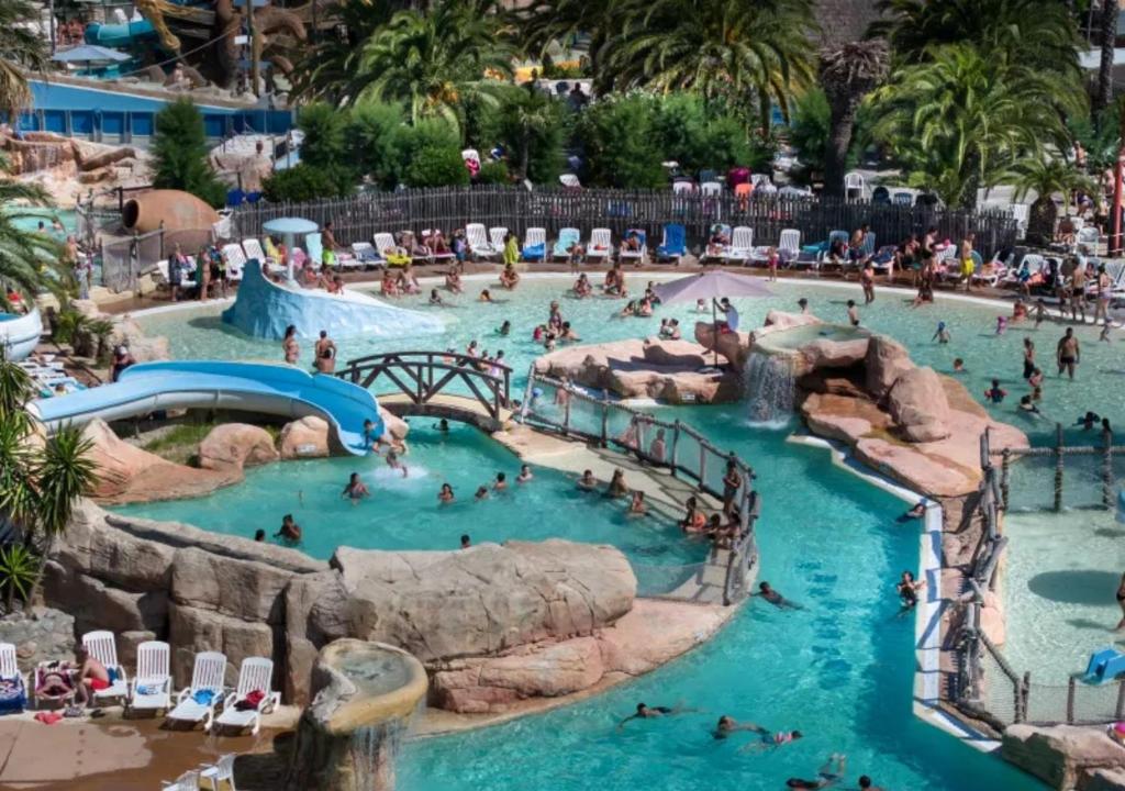 a group of people in a pool at a water park at Camping Les Sables d'Or Pirates World - Aquatique Vacances in Le Grau-dʼAgde