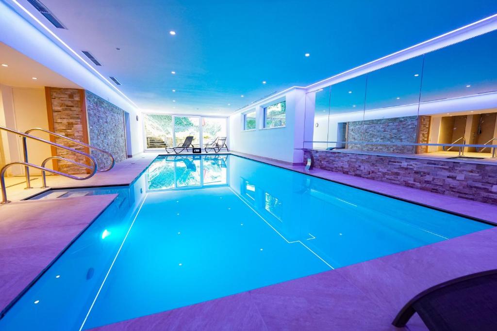a swimming pool with blue lighting in a house at Hotel Sonnhof in Innsbruck