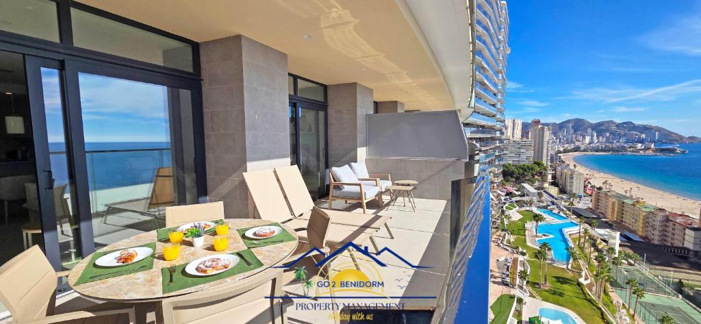 a balcony with a table and a view of the ocean at Nini Sunset Sailor Luxury Apartment in Benidorm
