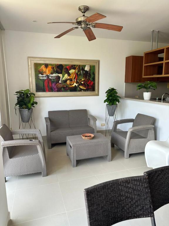 ein Wohnzimmer mit Stühlen und einem Deckenventilator in der Unterkunft CONDOMINIO LAGUNA CLUB "Amalfi" in Cartagena de Indias
