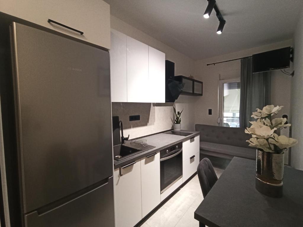 a kitchen with a stainless steel refrigerator and a table at Sodi Cozy apartment in Karditsa