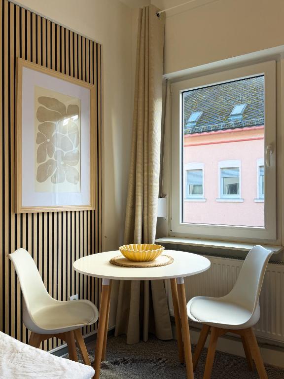 a room with a table and two chairs and a window at CityStay Montabaur in Montabaur