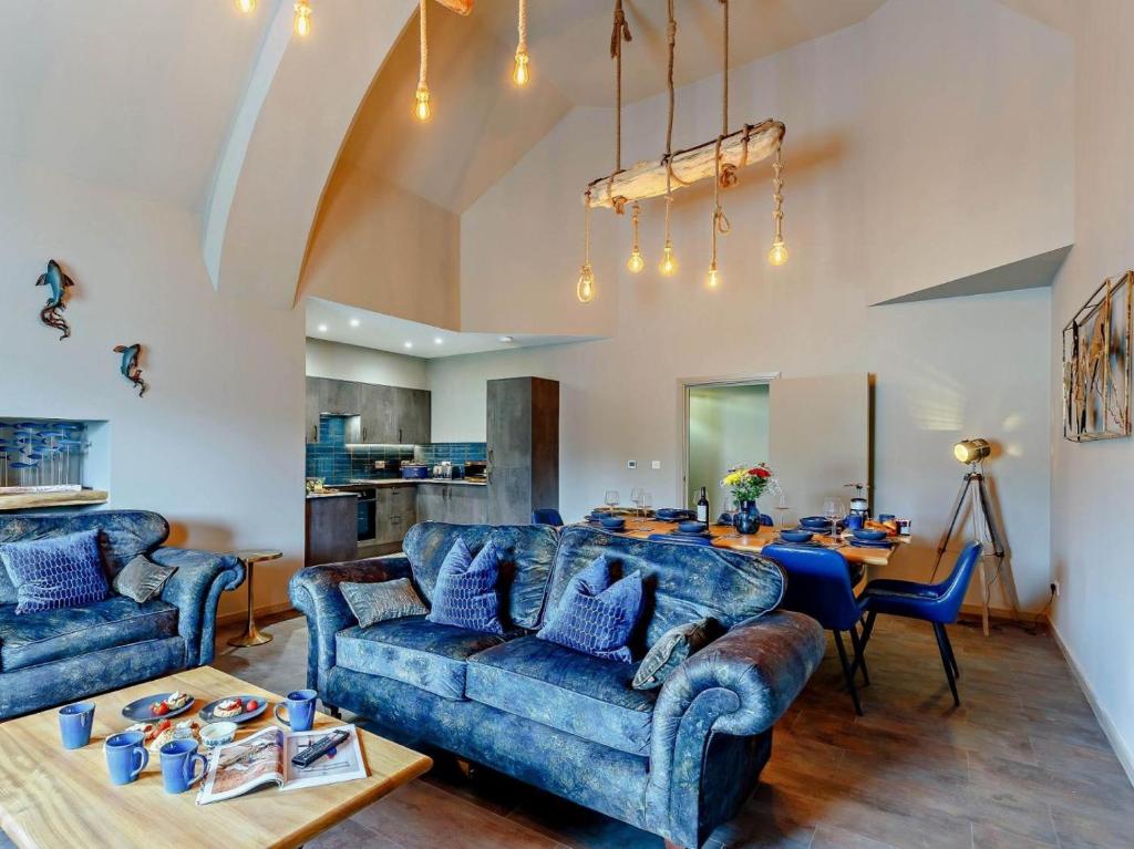 a living room with two blue couches and a table at 4 Bed in Newquay oc-90069 in Newquay