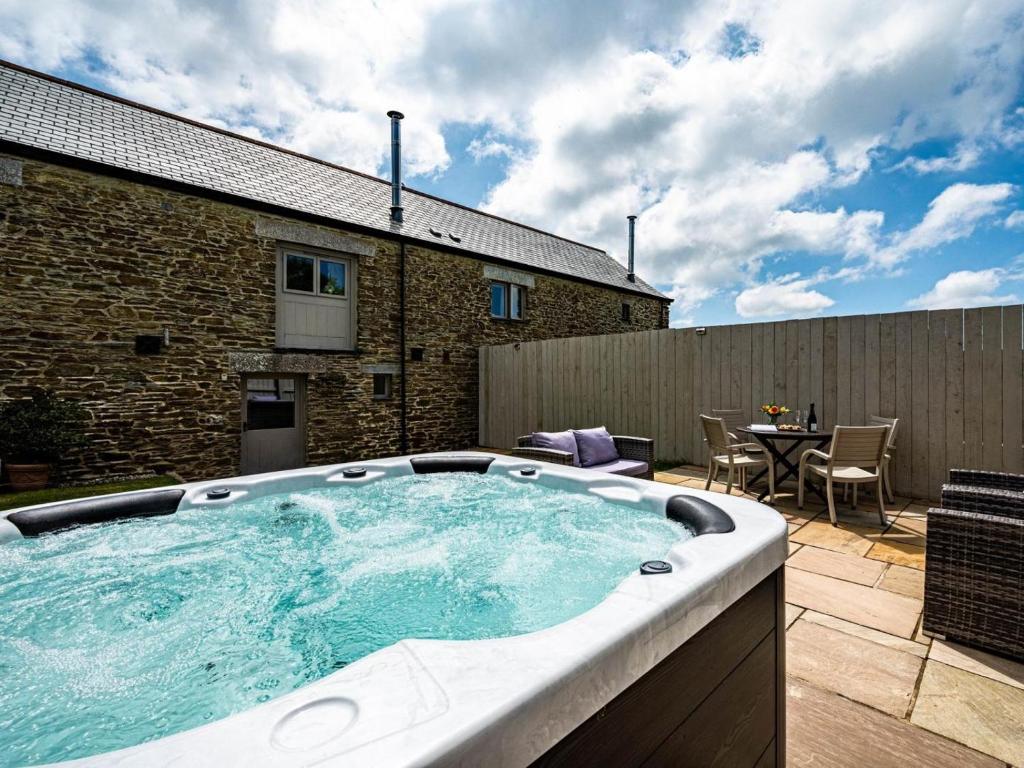 a large hot tub on a patio with a table at 2 Bed in Camelford oc-81245 in Camelford