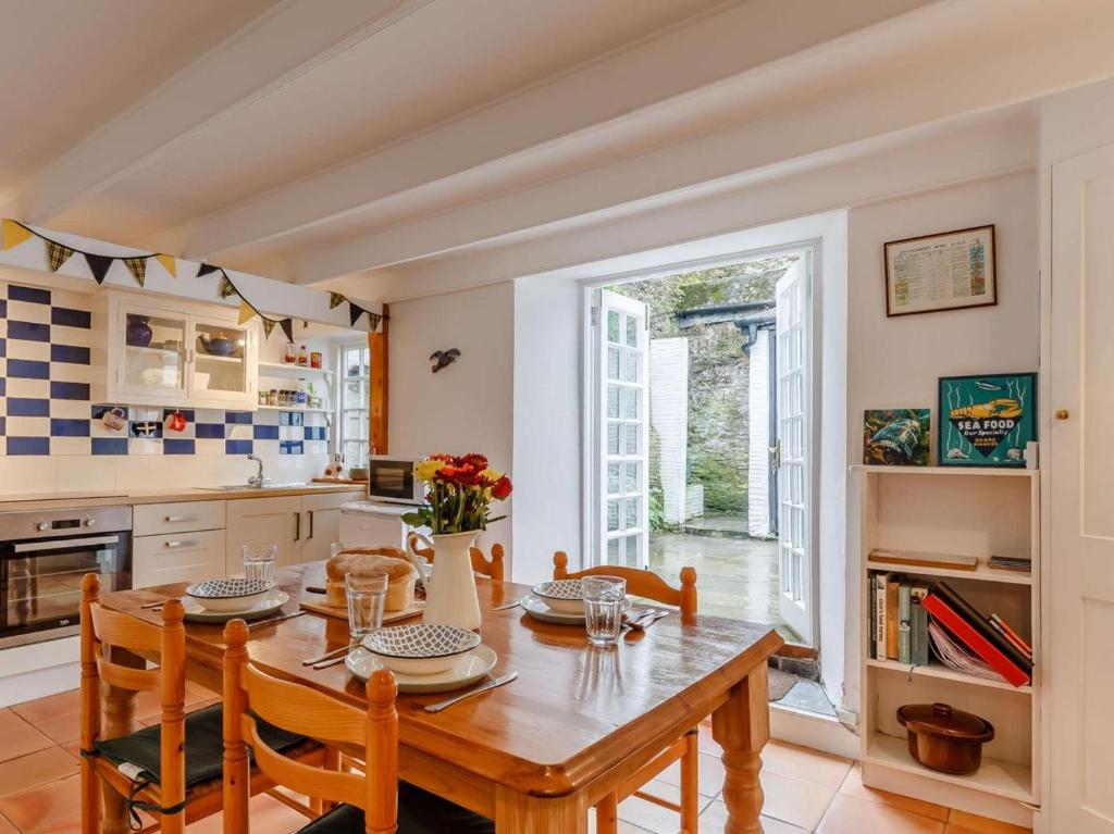 a kitchen and dining room with a wooden table and chairs at 2 Bed in Fowey oc-76624 in Fowey