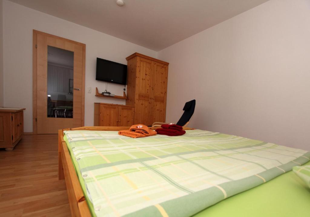 Schlafzimmer mit einem Bett mit grüner und weißer Bettwäsche in der Unterkunft Haus Wibmer in Kals am Großglockner